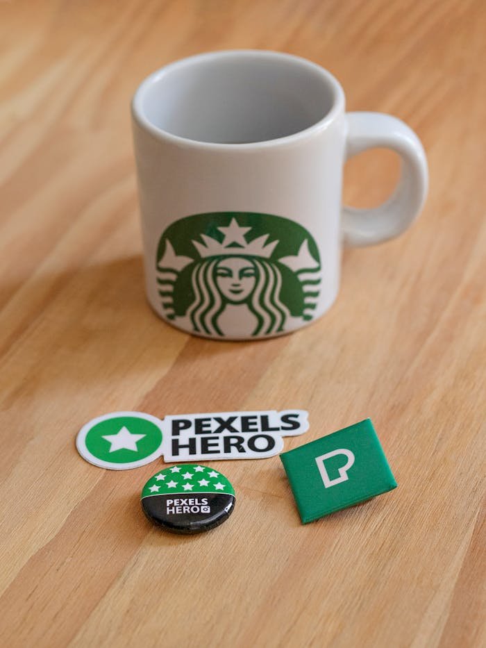 pexels-photo-5473927 Starbucks mug on wooden table with Pexels Hero stickers, pins, and badge. Perfect for brand-focused content.
